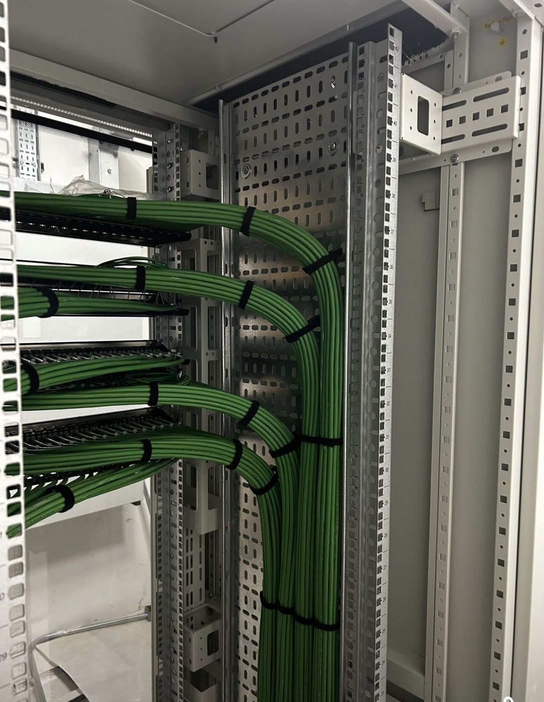 Green copper looms dressed into a comms room cabinet in London